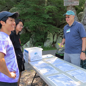 Trailhead ambassador in and outside setting helping visitors to Mohonk Preserve