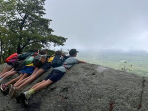 Campers enjoying laying on a rock face enjoying the view.