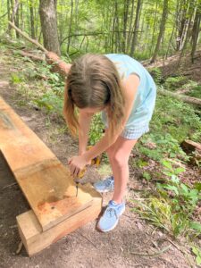 Camper using a drill to build a boardwalk.