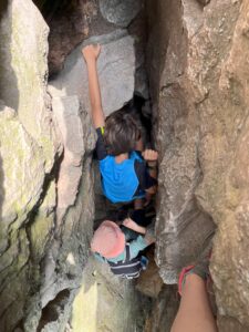 Campers climbing into a crevice.