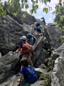 Campers navigating a rock scramble